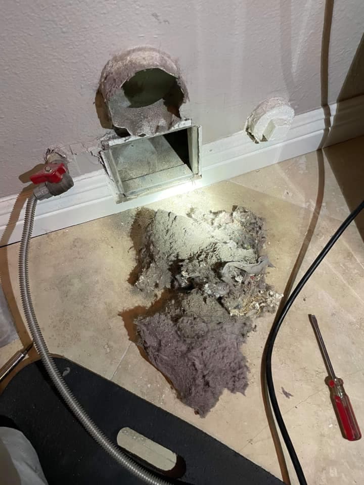 Dryer vent cleaning showing lint buildup and tools for maintenance near a vent outlet.