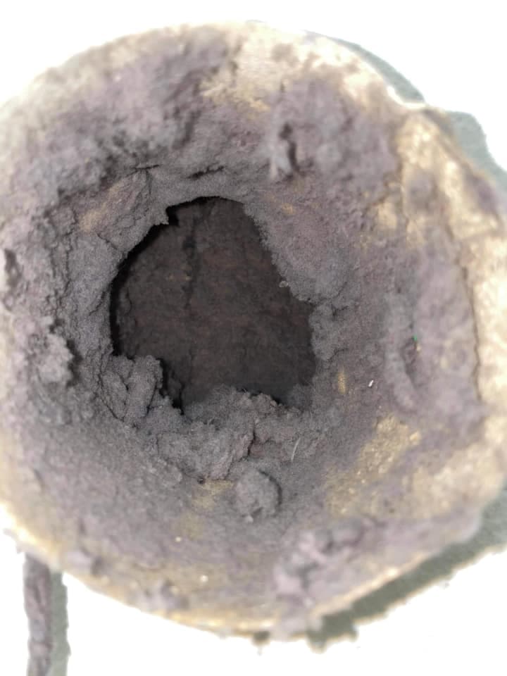 Interior view of a dusty, hollow space inside a worn-out sock.