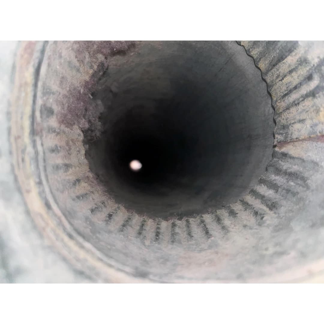 Close-up view inside a metallic pipe showing a smooth, circular interior surface.